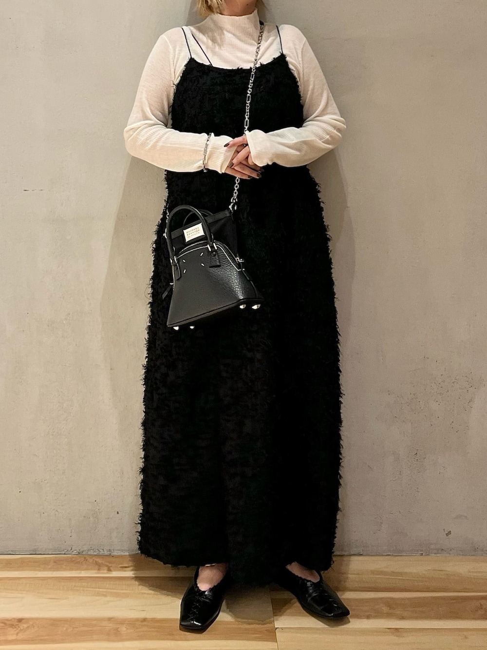 ブラック系のワンピース、ホワイト系のニット/セーターを着用したレディースの秋コーディネートの3枚目の写真