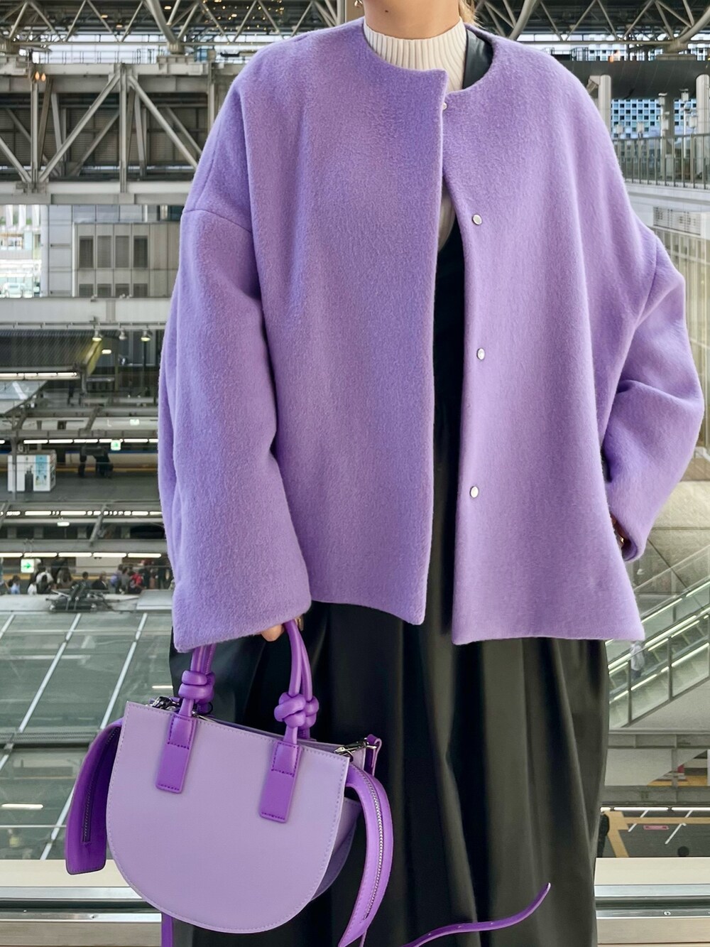 パープル系のノーカラージャケット、ブラック系のジャンパースカート、ホワイト系のニット/セーターを着用したレディースの秋コーディネートの5枚目の写真