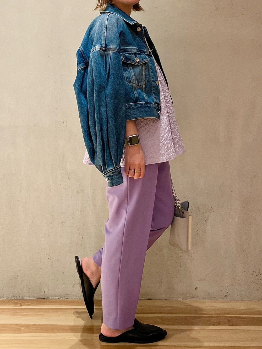 グレー系のショルダーバッグ、ブルー系のデニムジャケット、パープル系のその他パンツを着用したレディースの冬コーディネートの2枚目の写真