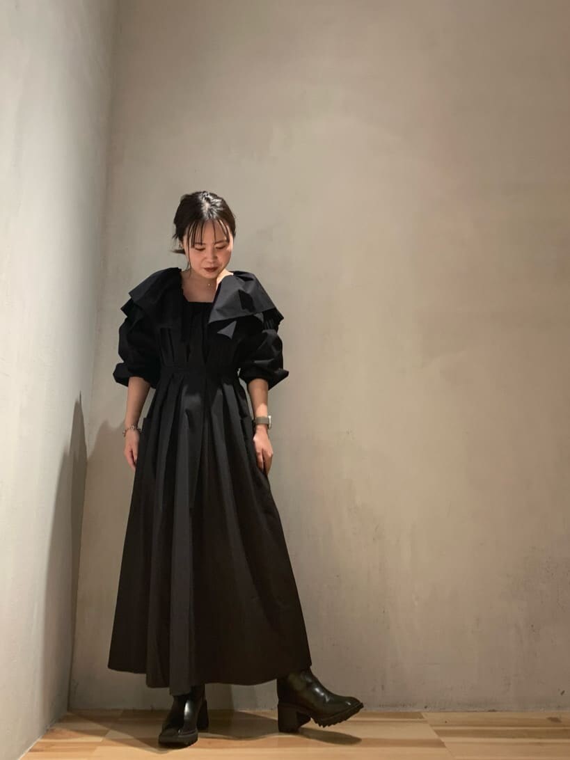 ブラック系のブーツ、ブラック系のワンピースを着用したレディースの秋コーディネートの2枚目の写真