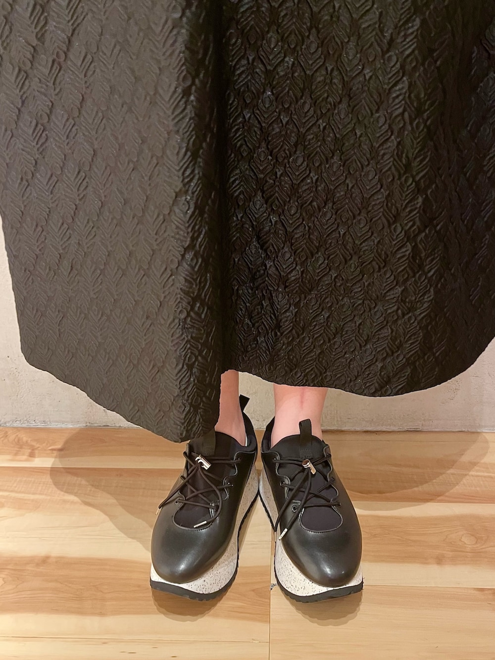 ブルー系のカーディガン/ボレロ、ブラック系のスカート、ブラック系のスニーカーを着用したレディースの春コーディネートの7枚目の写真