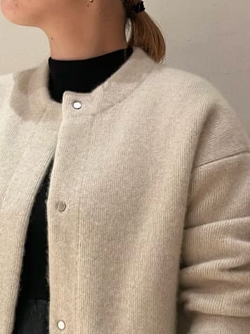 ベージュ系のショルダーバッグ、ホワイト系のカーディガン/ボレロ、ブラウン系のブーツを着用したレディースの秋コーディネートの8枚目の写真