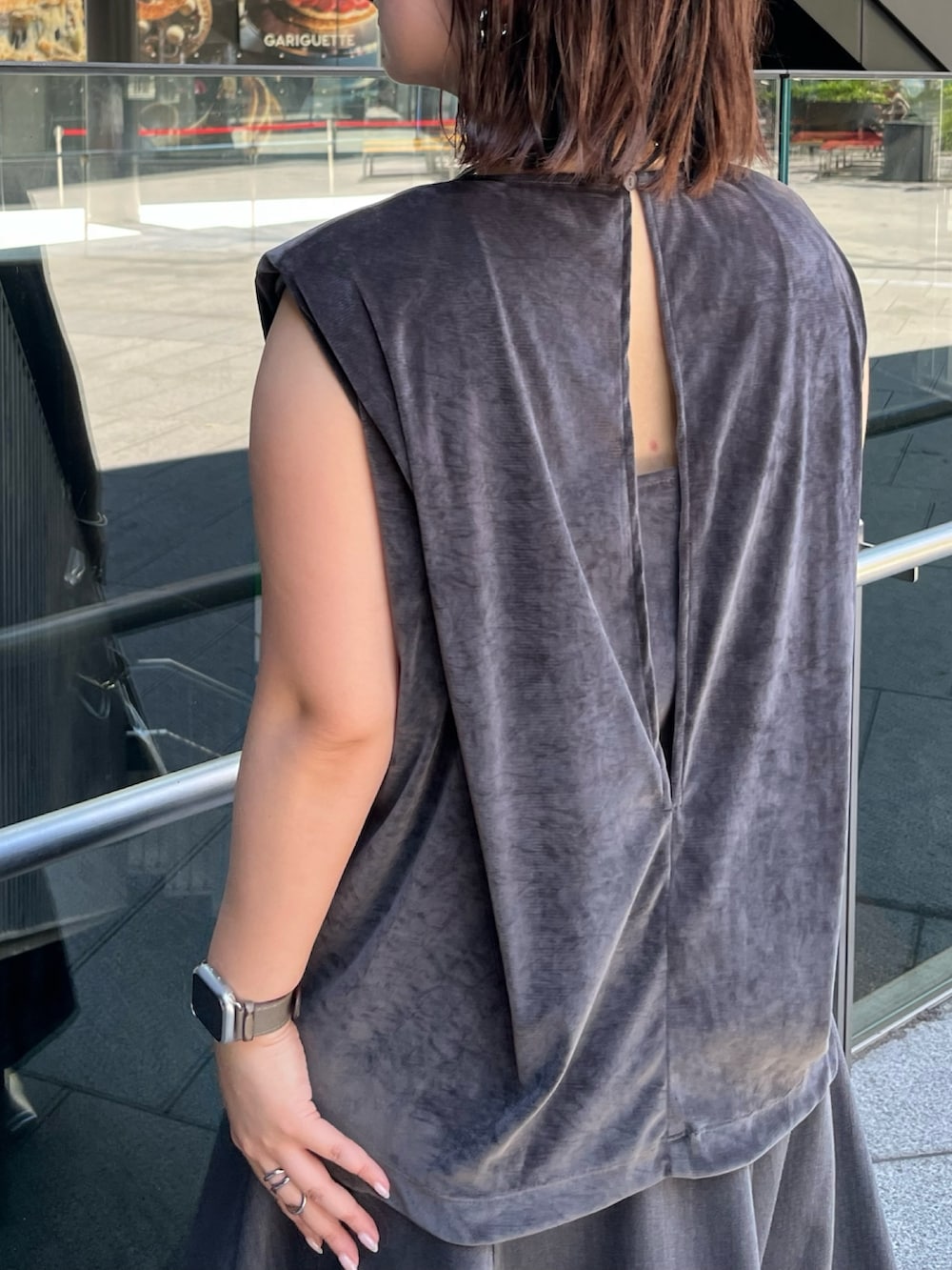 グレー系のスカート、ゴールド系のハンドバッグ、グレー系のTシャツ/カットソーを着用したレディースの夏コーディネートの8枚目の写真