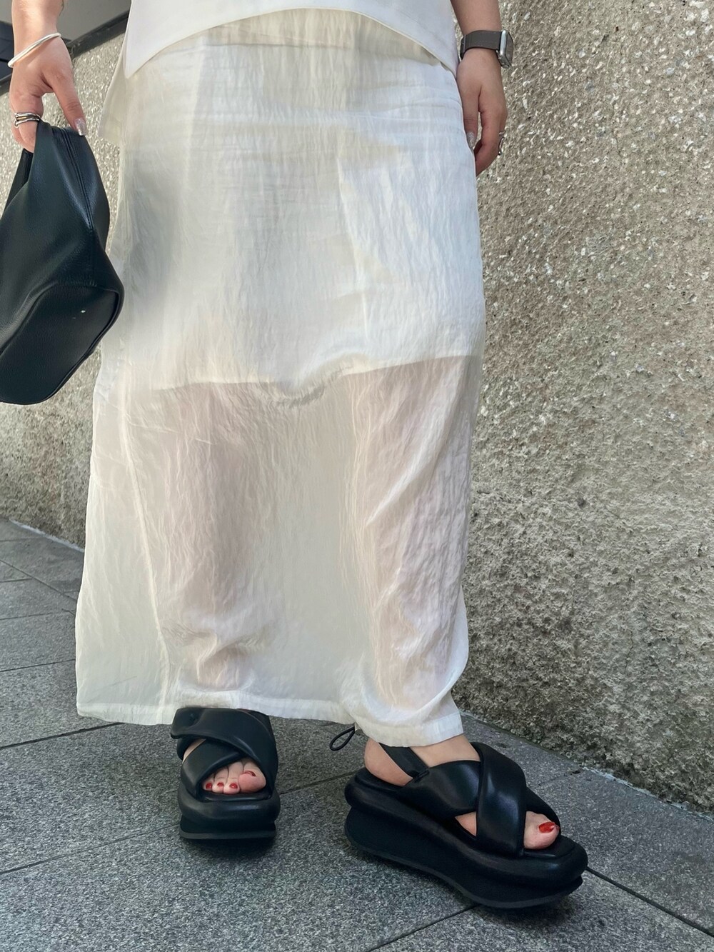 ホワイト系のTシャツ/カットソー、ホワイト系のスカート、ブラック系のサンダルを着用したレディースの春コーディネートの7枚目の写真