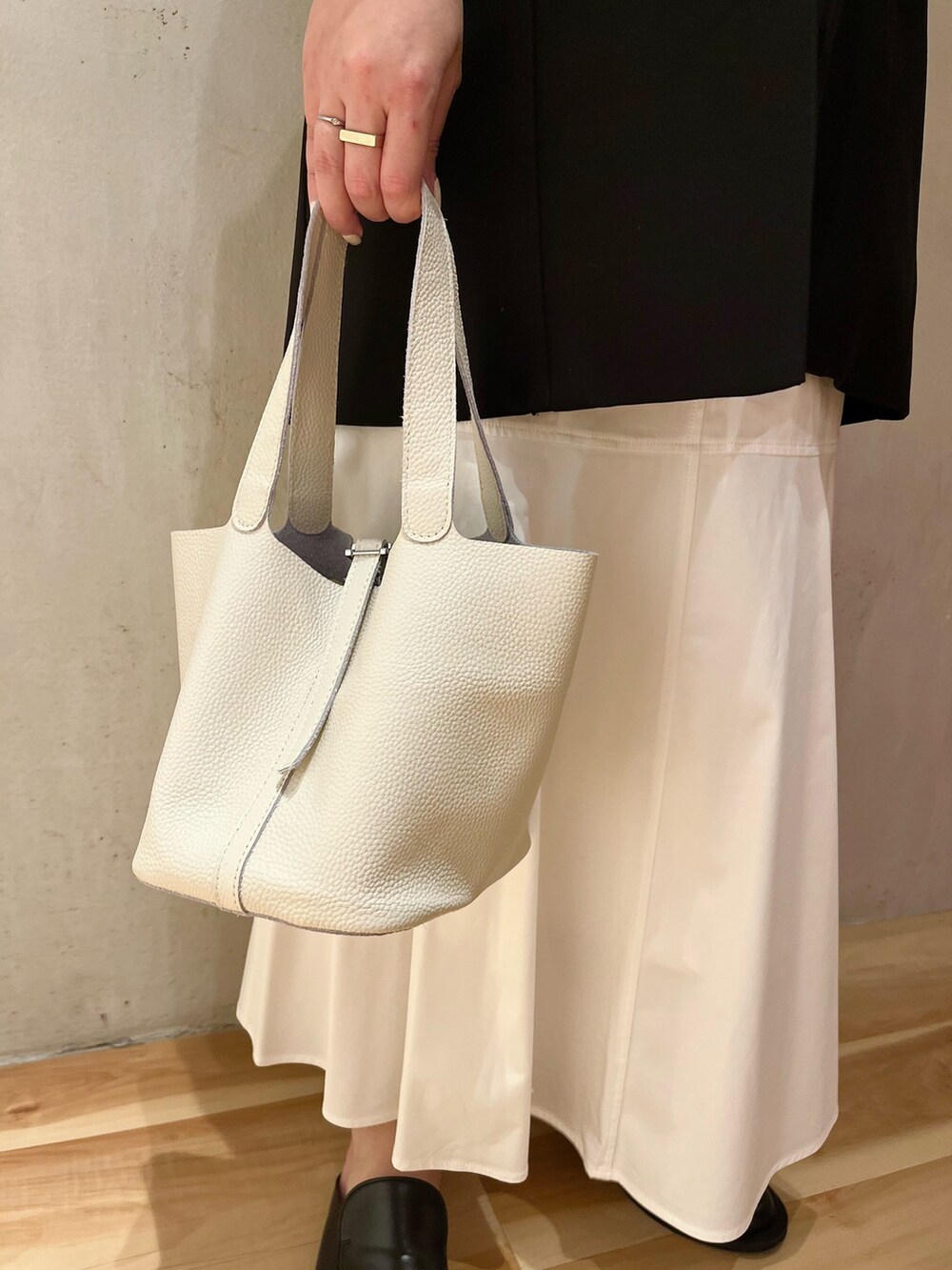 ホワイト系のスカート、ホワイト系のハンドバッグ、ブラック系のテーラードジャケットを着用したレディースの冬コーディネートの8枚目の写真