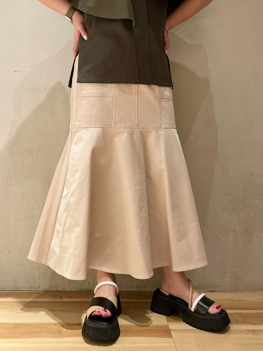 グリーン系のTシャツ/カットソー、ベージュ系のスカート、その他のサンダルを着用したレディースの春コーディネートの7枚目の写真