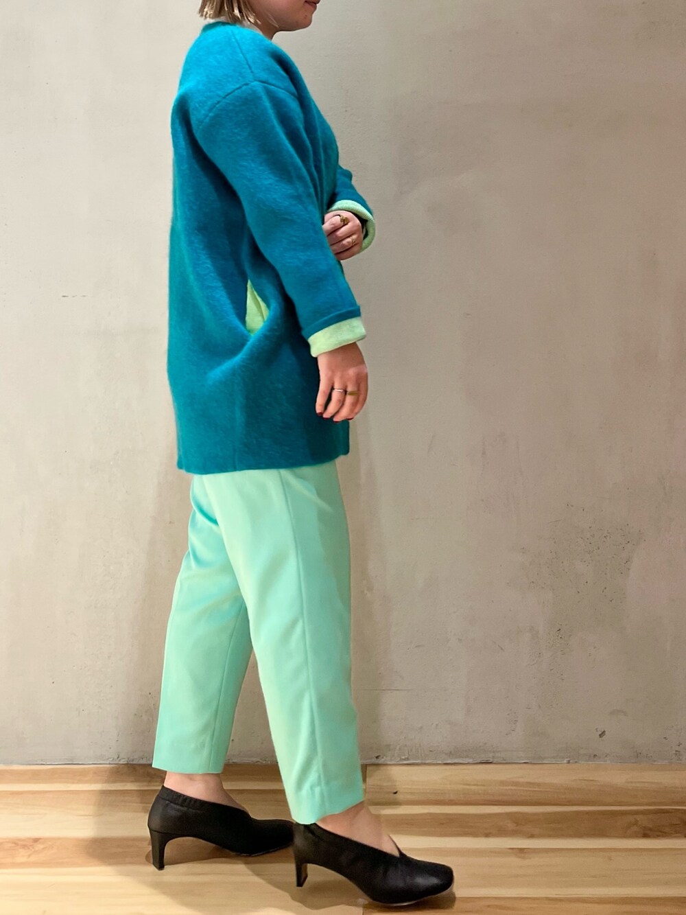 グリーン系のカーディガン/ボレロ、ホワイト系のニット/セーター、グリーン系のその他パンツを着用したレディースの冬コーディネートの4枚目の写真