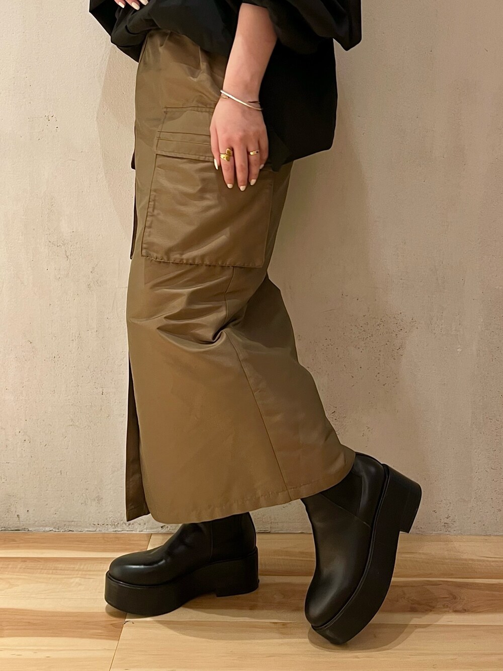 ブラック系のシャツ/ブラウス、ブラウン系のスカート、ブラック系のブーツを着用したレディースの春コーディネートの8枚目の写真