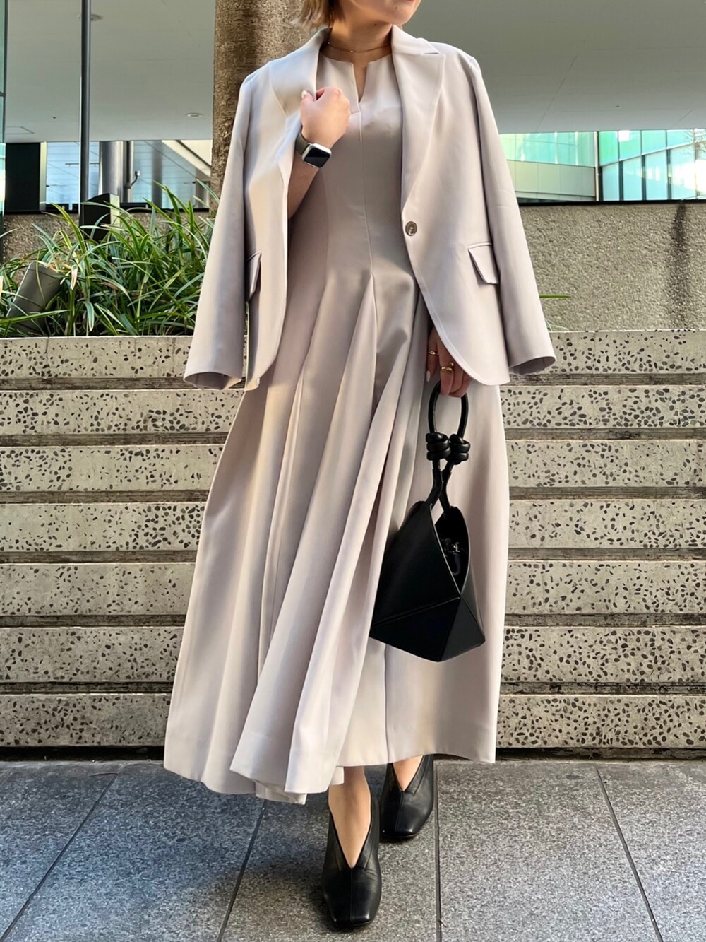 ベージュ系のワンピース、ベージュ系のテーラードジャケット、ブラック系のハンドバッグを着用したレディースの冬コーディネートの3枚目の写真