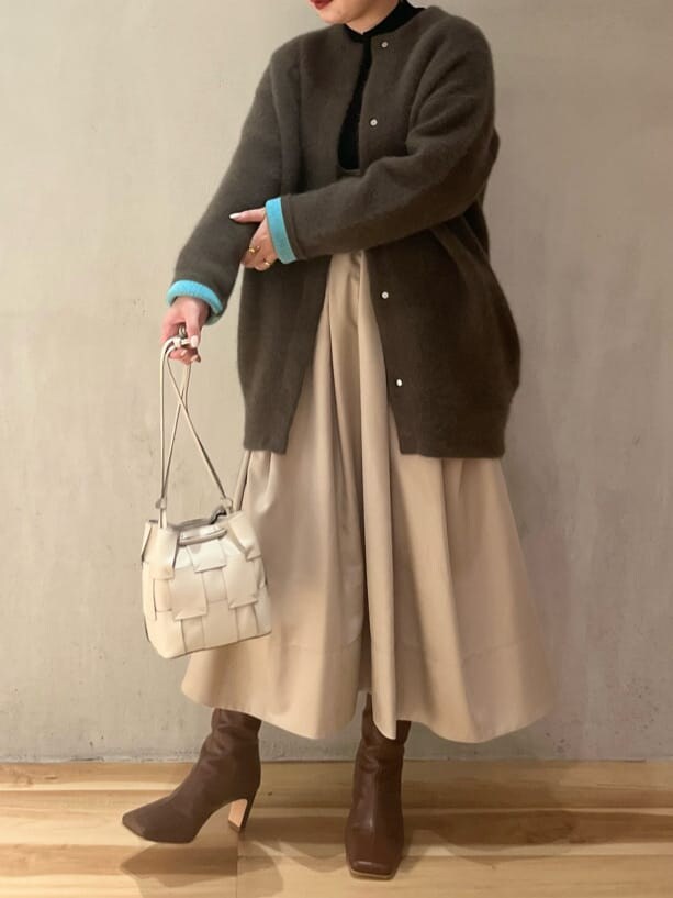 ベージュ系のジャンパースカート、ブラウン系のブーツ、ベージュ系のその他アウターを着用したレディースの秋コーディネートの3枚目の写真