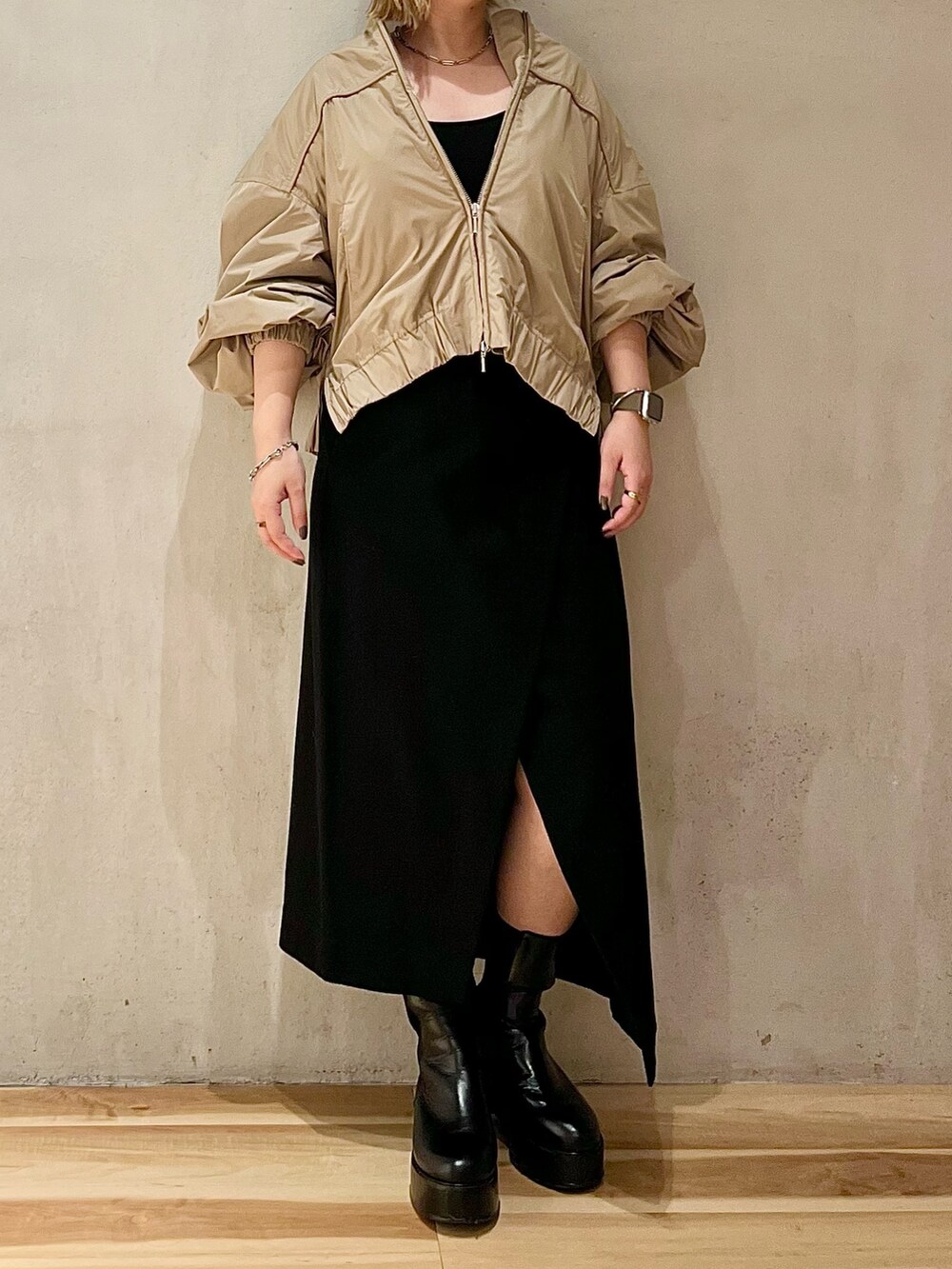 ベージュ系のブルゾン、ブラック系のスカート、ブラック系のブーツを着用したレディースの秋コーディネートの3枚目の写真