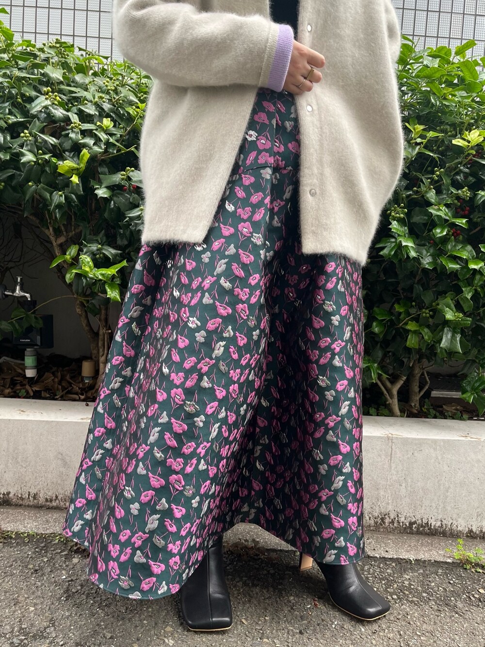 ホワイト系のノーカラージャケット、グリーン系のスカート、ブラック系のブーツを着用したレディースの夏コーディネートの9枚目の写真