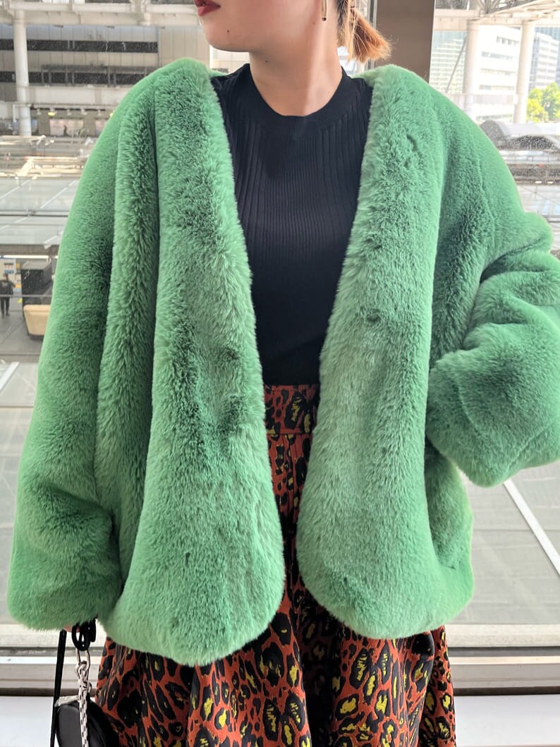 ブラック系のニット/セーター、ホワイト系のショルダーバッグ、グリーン系のノーカラーコートを着用したレディースの夏コーディネートの6枚目の写真