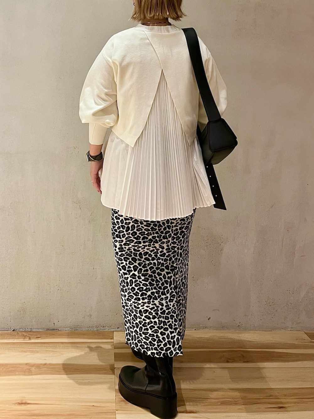 ホワイト系のスカート、ホワイト系のニット/セーター、ブラック系のショルダーバッグを着用したレディースの秋コーディネートの3枚目の写真