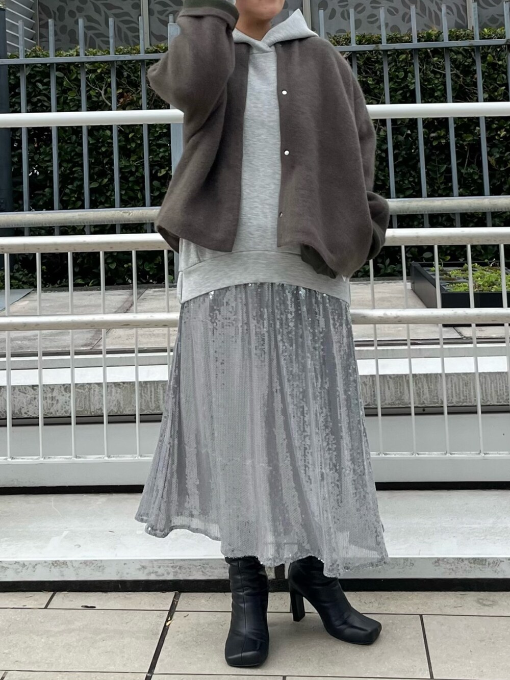 ブラウン系のカーディガン/ボレロ、グレー系のワンピース、ブラック系のブーツを着用したレディースの秋コーディネートの4枚目の写真