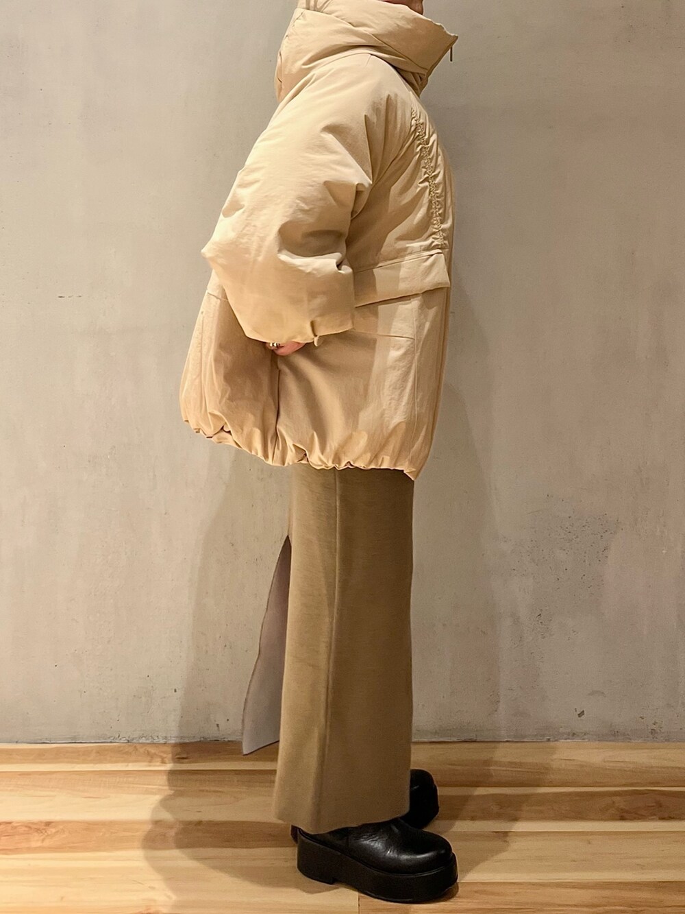 ベージュ系のダウンジャケット/コート、ベージュ系のスカート、ベージュ系のニット/セーターを着用したレディースの冬コーディネートの3枚目の写真