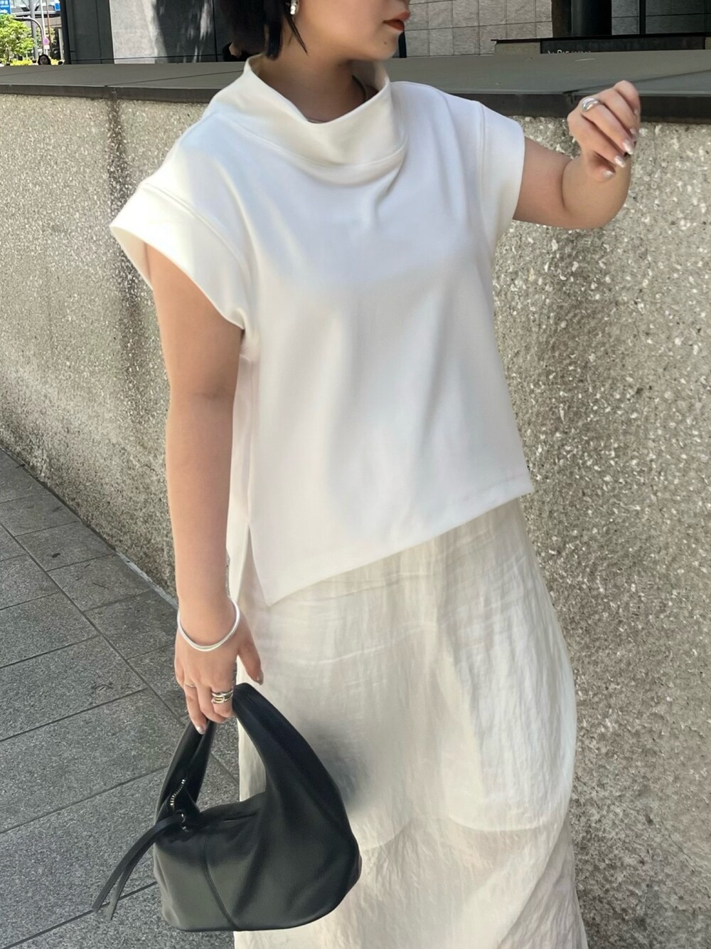 ホワイト系のTシャツ/カットソー、ホワイト系のスカート、ブラック系のサンダルを着用したレディースの春コーディネートの5枚目の写真