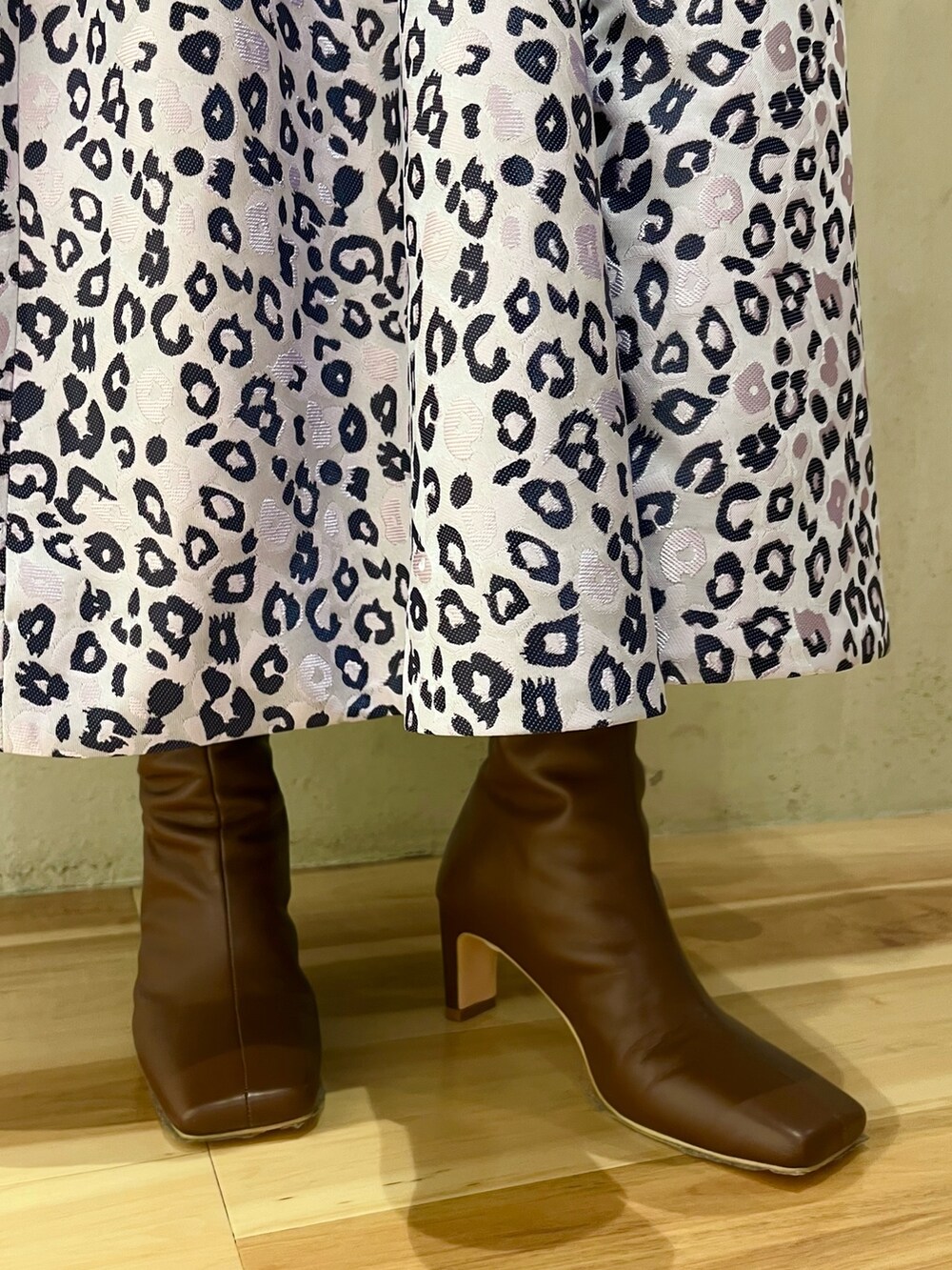 ホワイト系のニット/セーター、パープル系のスカート、ブラウン系のブーツを着用したレディースの冬コーディネートの10枚目の写真