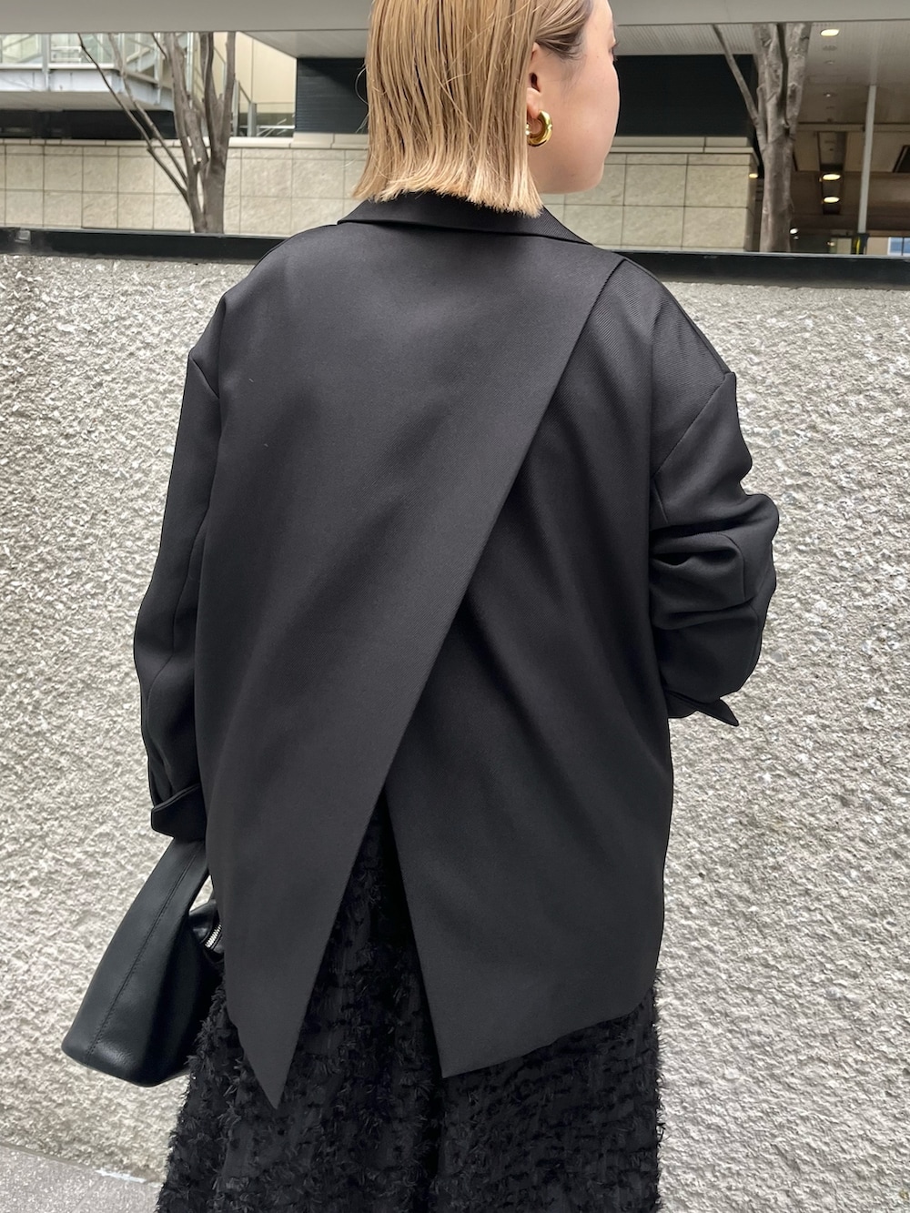 ブラック系のテーラードジャケット、ブラック系のニット/セーター、ブラック系のワンピースを着用したレディースの冬コーディネートの5枚目の写真