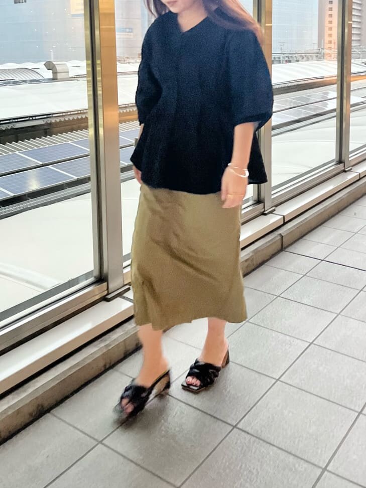 ブラック系のシャツ/ブラウス、ブラック系のサンダル、ベージュ系のスカートを着用したレディースの春コーディネートの2枚目の写真