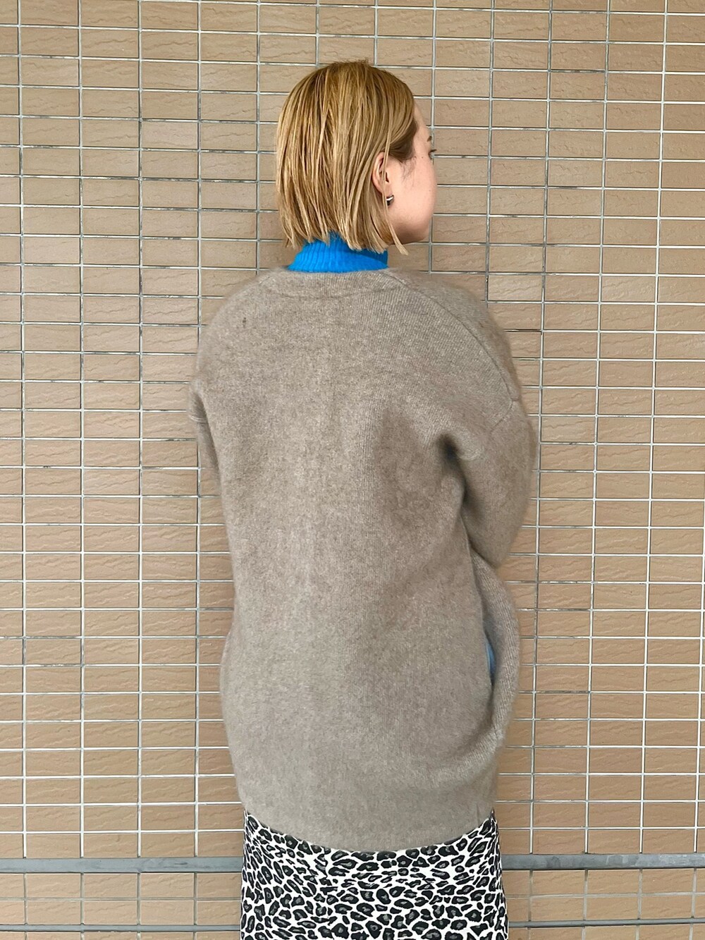 ベージュ系のノーカラージャケット、ブラック系のブーツ、ブラック系のハンドバッグを着用したレディースの夏コーディネートの5枚目の写真