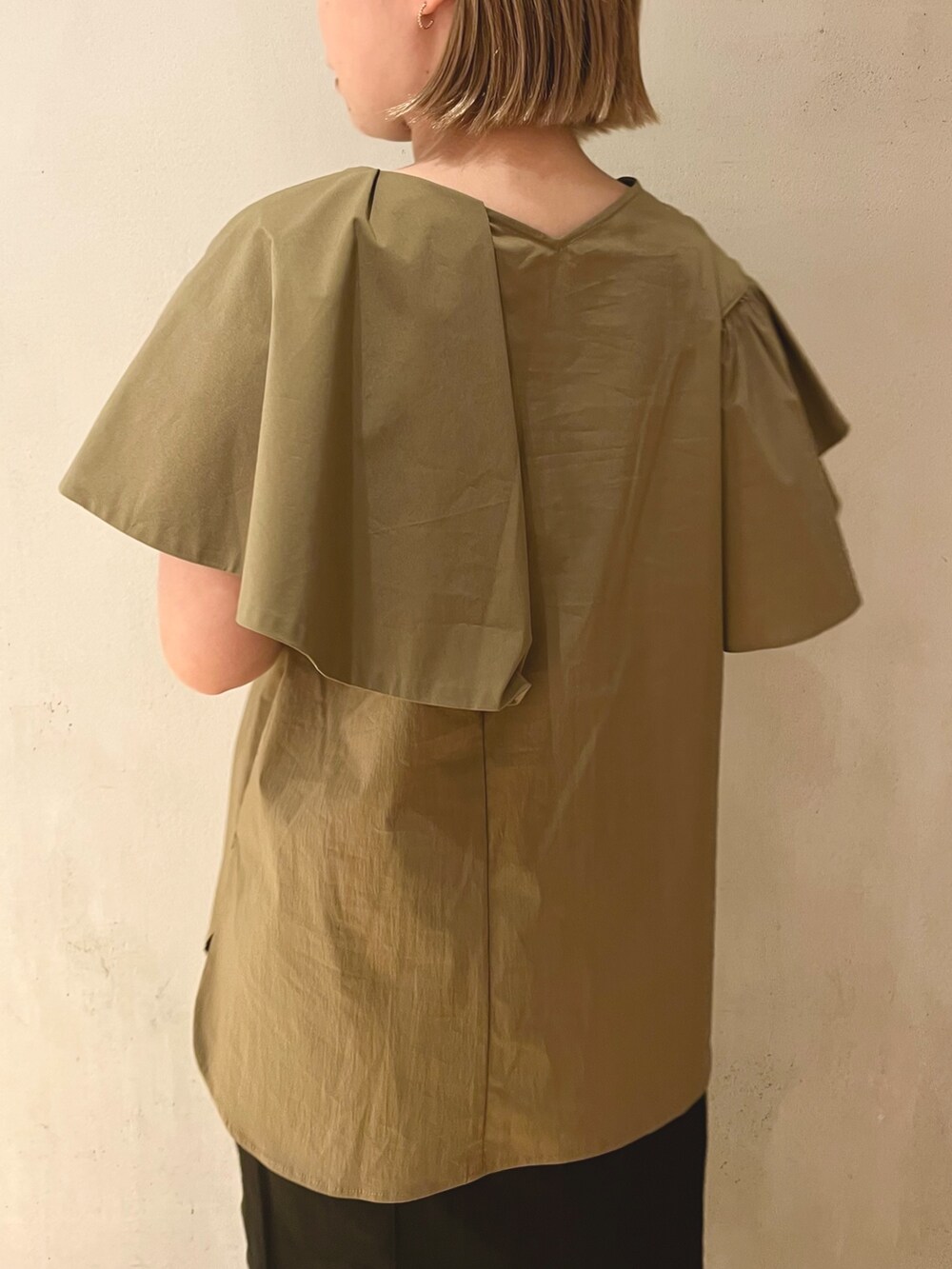 グリーン系のシャツ/ブラウス、ブラック系のスカート、ブラック系のサンダルを着用したレディースの冬コーディネートの6枚目の写真