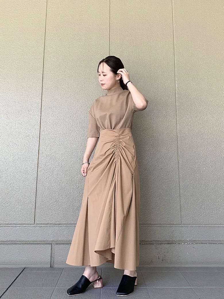 ブラック系のサンダル、ベージュ系のワンピースを着用したレディースの夏コーディネートの2枚目の写真