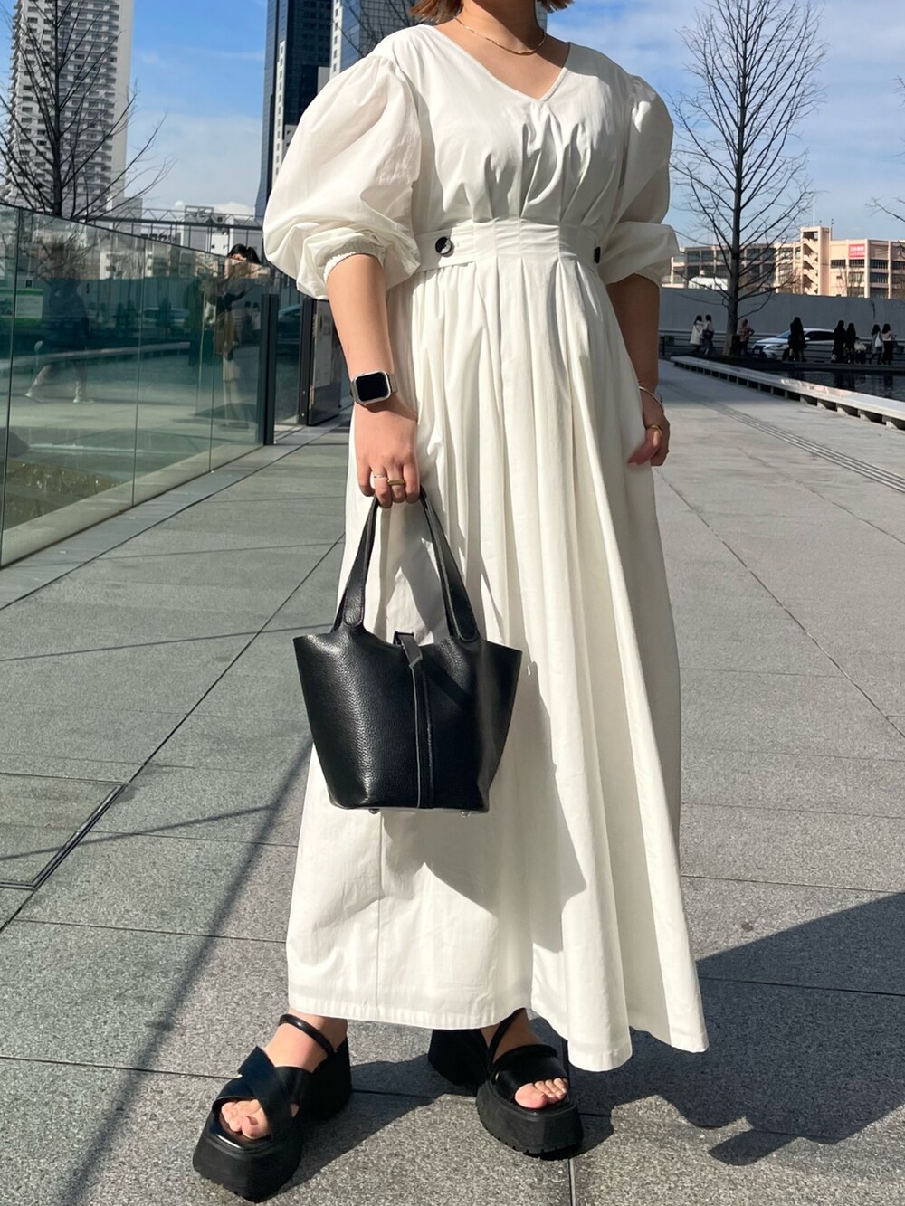 ブラック系のサンダル、ホワイト系のワンピース、ブラック系のハンドバッグを着用したレディースの冬コーディネートの4枚目の写真