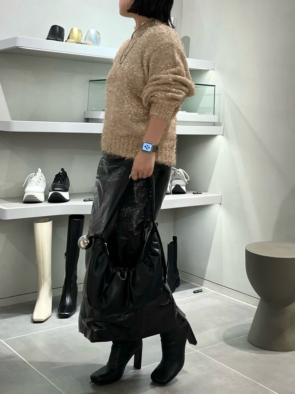 ベージュ系のニット/セーター、ブラック系のブーツ、ブラック系のハンドバッグを着用したレディースの秋コーディネートの3枚目の写真