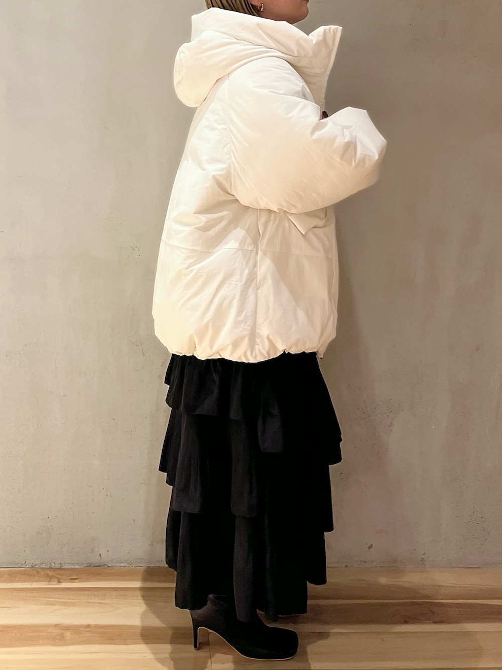 ホワイト系のダウンジャケット/コート、パープル系のニット/セーター、ブラック系のスカートを着用したレディースの夏コーディネートの2枚目の写真