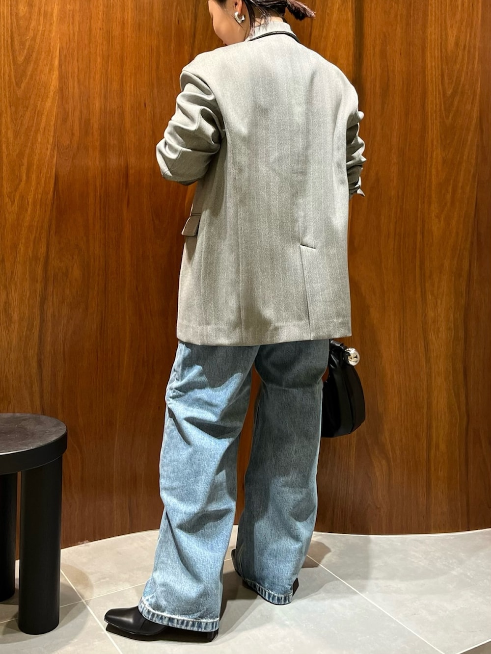 ブラック系のテーラードジャケット、レッド系のカーディガン/ボレロ、ブラック系のハンドバッグを着用したレディースの秋コーディネートの4枚目の写真