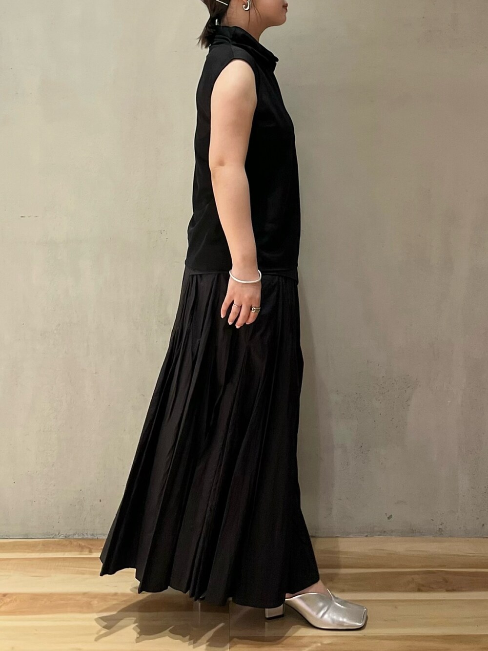 ブラック系のシャツ/ブラウス、ブラック系のスカート、シルバー系のパンプスを着用したレディースの夏コーディネートの2枚目の写真