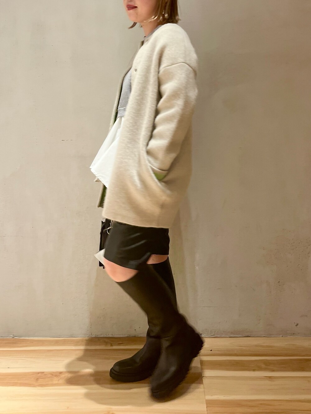 ホワイト系のカーディガン/ボレロ、グレー系のニット/セーターを着用したレディースの冬コーディネートの2枚目の写真