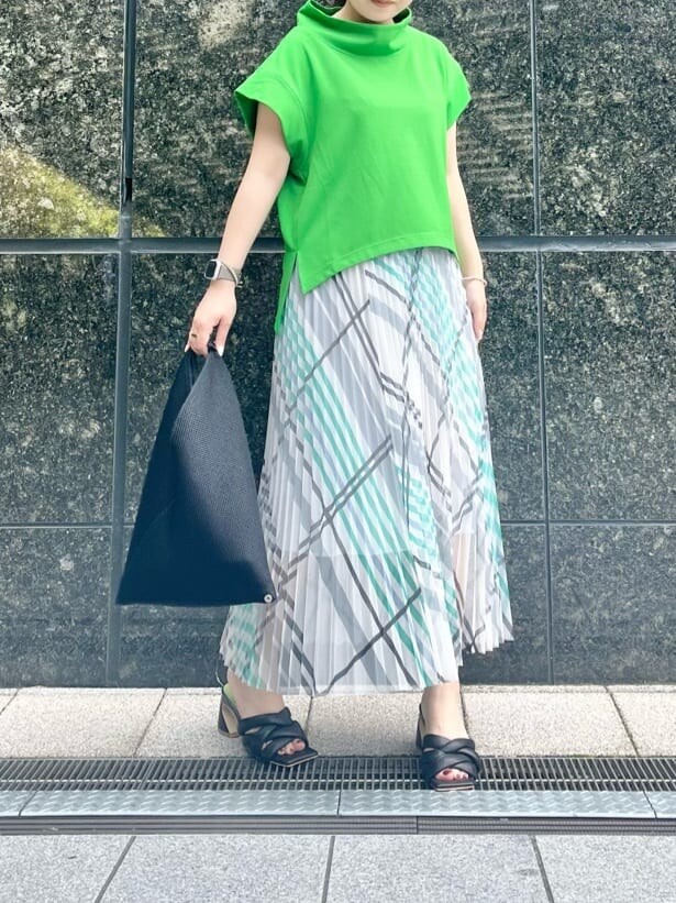 ブラック系のサンダル、グリーン系のTシャツ/カットソー、ホワイト系のスカートを着用したレディースの春コーディネートの3枚目の写真