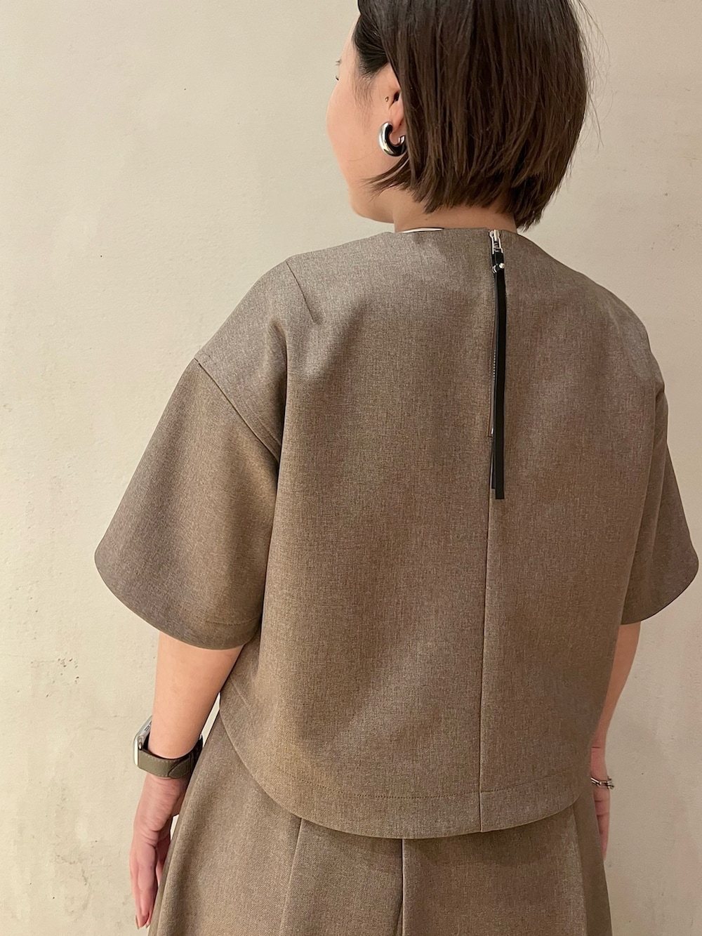 ブラウン系のスカート、ブラウン系のシャツ/ブラウス、ホワイト系のブーツを着用したレディースの春コーディネートの6枚目の写真