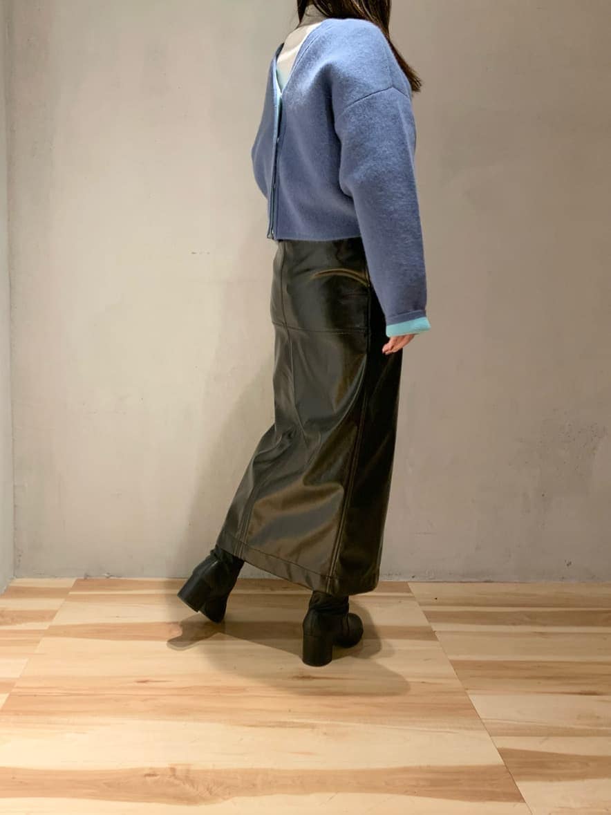 ブラック系のスカート、ホワイト系のニット/セーター、ブルー系のニット/セーターを着用したレディースの冬コーディネートの3枚目の写真