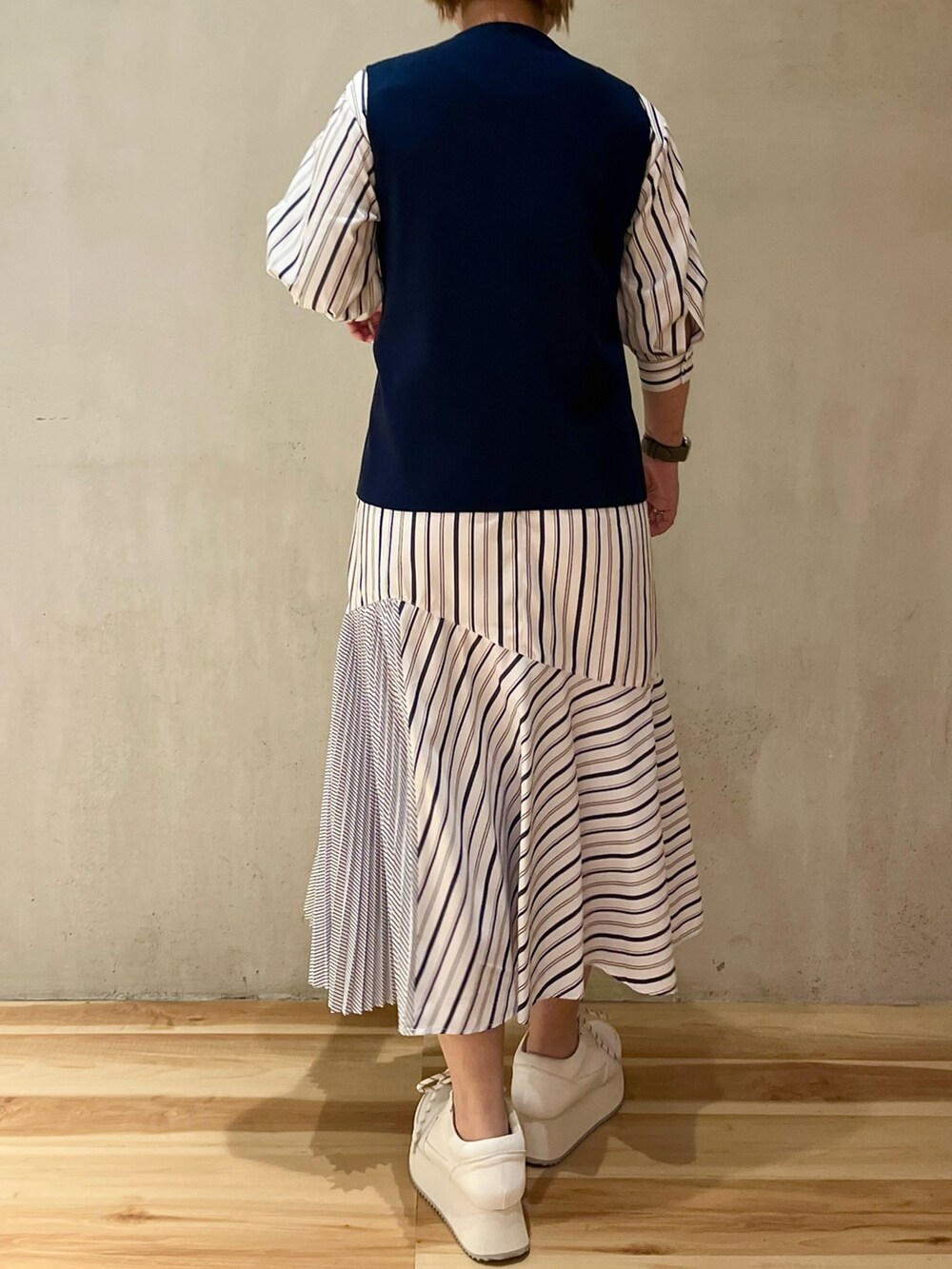 ホワイト系のスニーカー、ブルー系のワンピースを着用したレディースの冬コーディネートの3枚目の写真