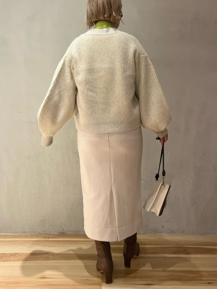 ブラウン系のブーツ、ベージュ系のショルダーバッグ、グリーン系のニット/セーターを着用したレディースの秋コーディネートの3枚目の写真