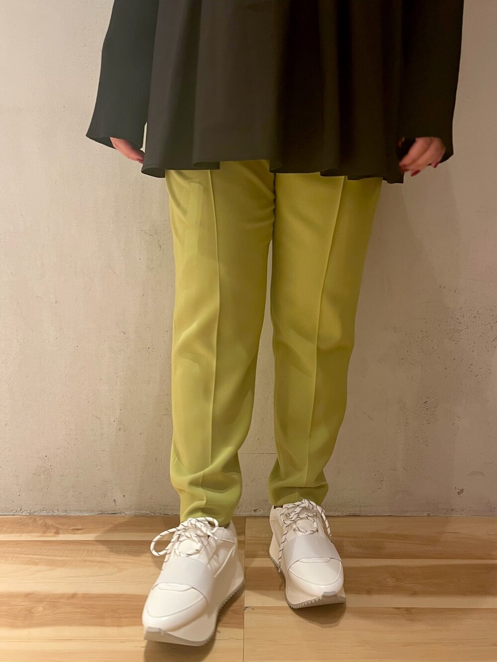 ブラック系のニット/セーター、グリーン系のその他パンツ、ホワイト系のスニーカーを着用したレディースの冬コーディネートの7枚目の写真