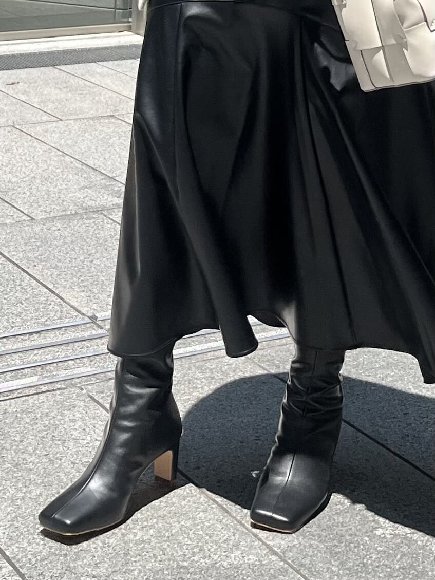 ブラック系のスカート、ホワイト系のニット/セーター、ホワイト系のカーディガン/ボレロを着用したレディースの夏コーディネートの8枚目の写真