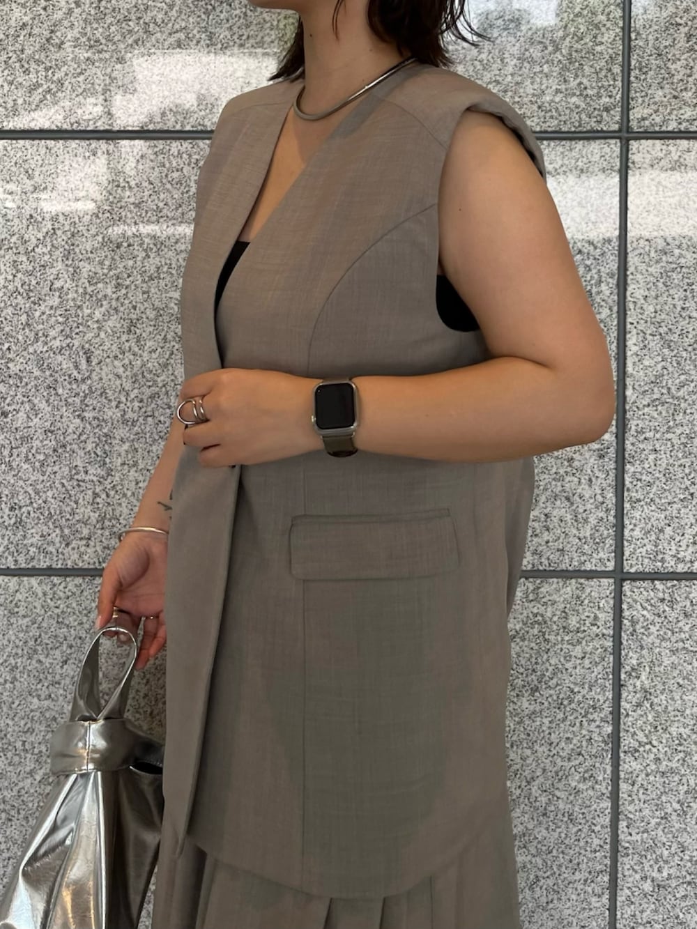 グレー系のワンピース、シルバー系のハンドバッグ、シルバー系のブーツを着用したレディースの夏コーディネートの8枚目の写真