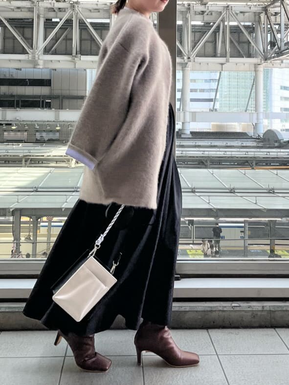 ブラック系のジャンパースカート、ホワイト系のショルダーバッグ、ベージュ系のシャツ/ブラウスを着用したレディースの夏コーディネートの6枚目の写真