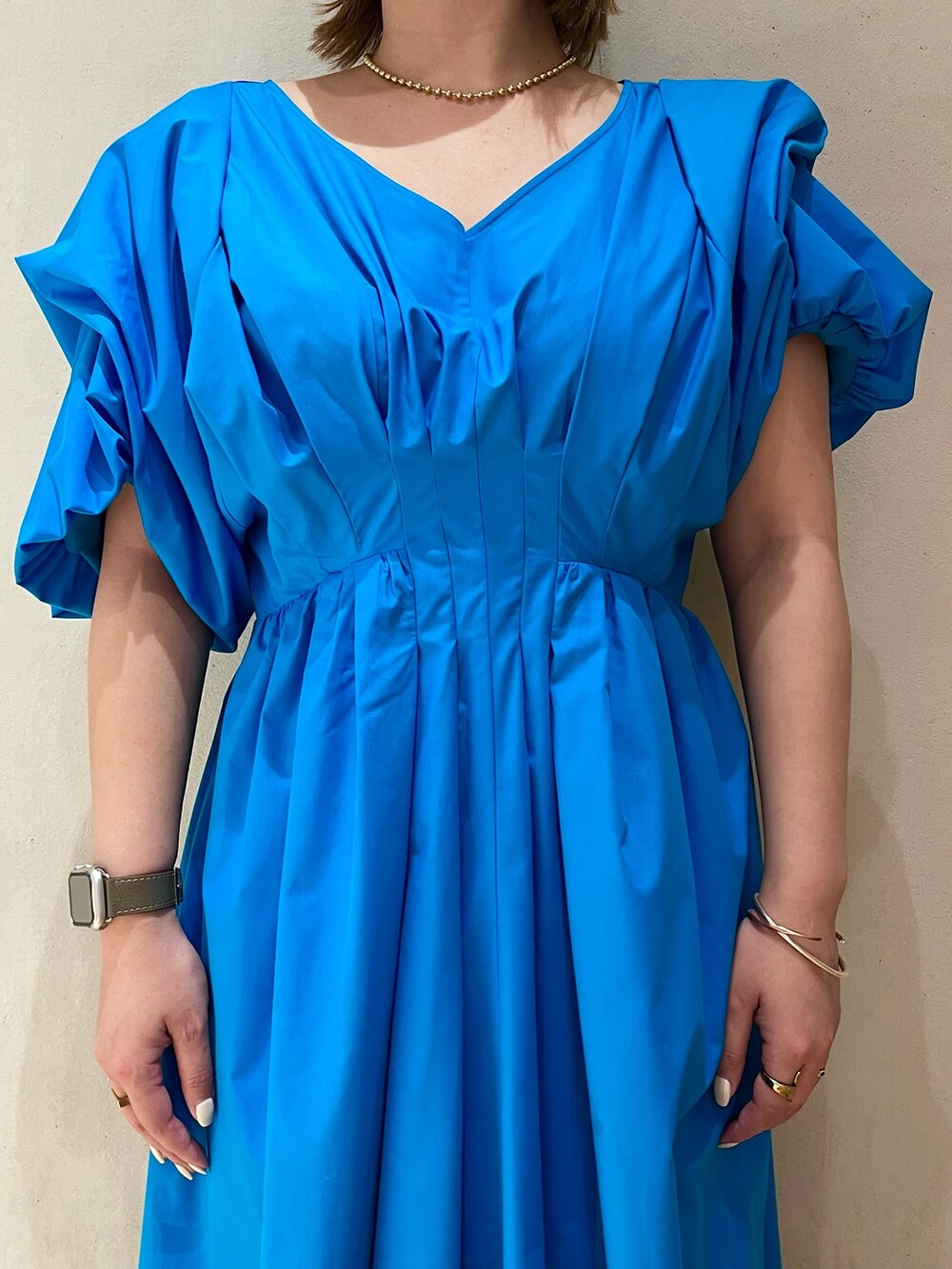 ブルー系のワンピース、ホワイト系のサンダル、ゴールド系のネックレスを着用したレディースの冬コーディネートの9枚目の写真