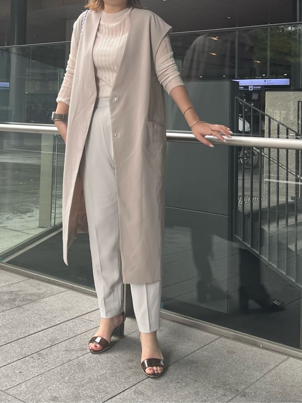 ベージュ系のショルダーバッグ、グレー系のノーカラージャケット、グレー系のその他パンツを着用したレディースの夏コーディネートの2枚目の写真