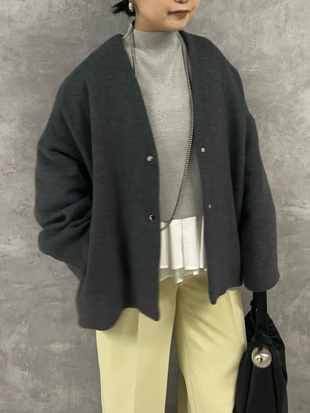 グレー系のノーカラージャケット、グレー系のニット/セーター、イエロー系のその他パンツを着用したレディースの秋コーディネートの5枚目の写真