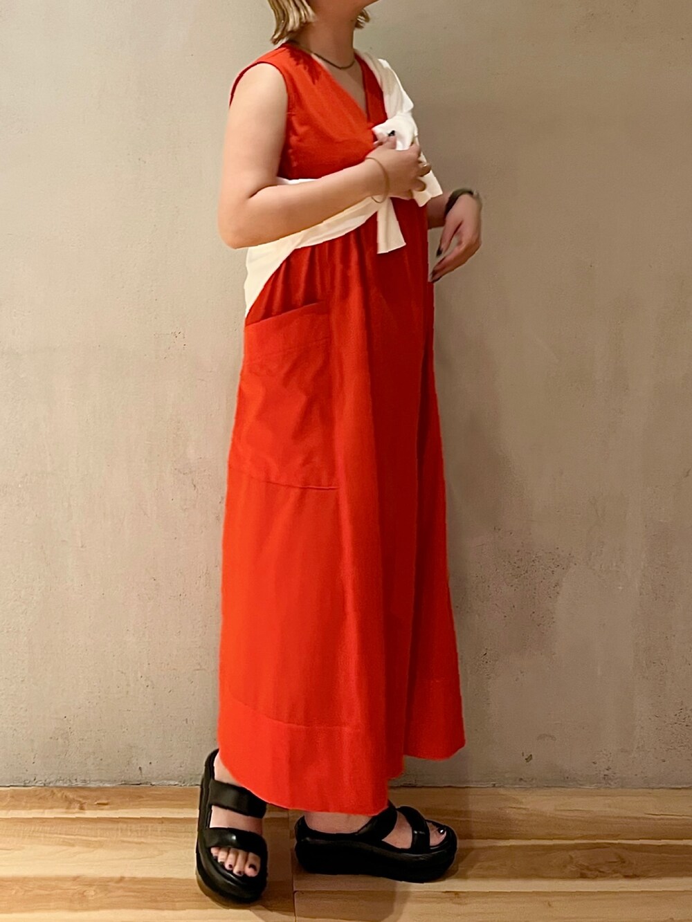 ホワイト系のカーディガン/ボレロ、ブラック系のサンダル、レッド系のワンピースを着用したレディースの夏コーディネートの2枚目の写真