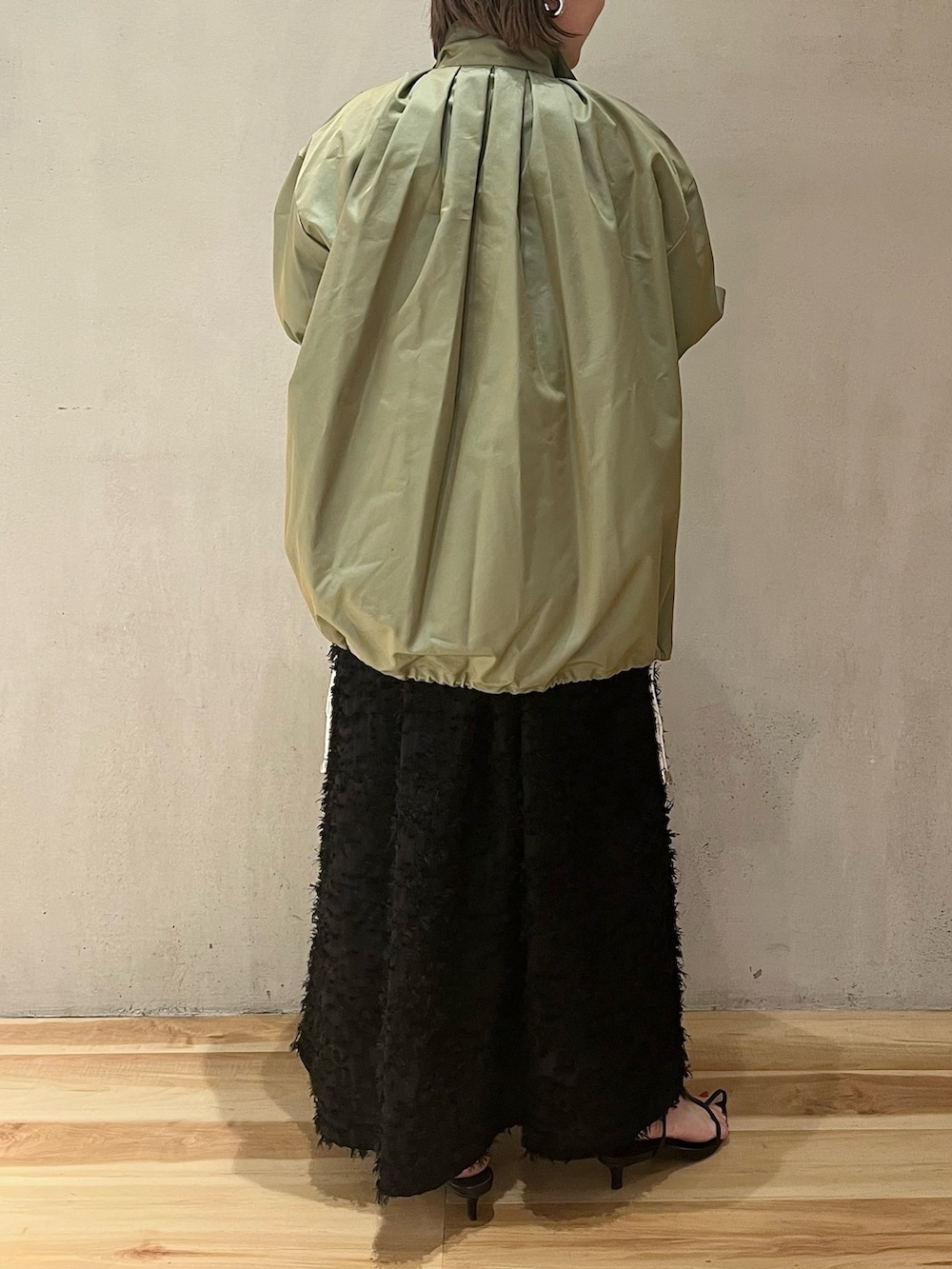 グリーン系のミリタリージャケット、ブラック系のワンピースを着用したレディースの春コーディネートの5枚目の写真