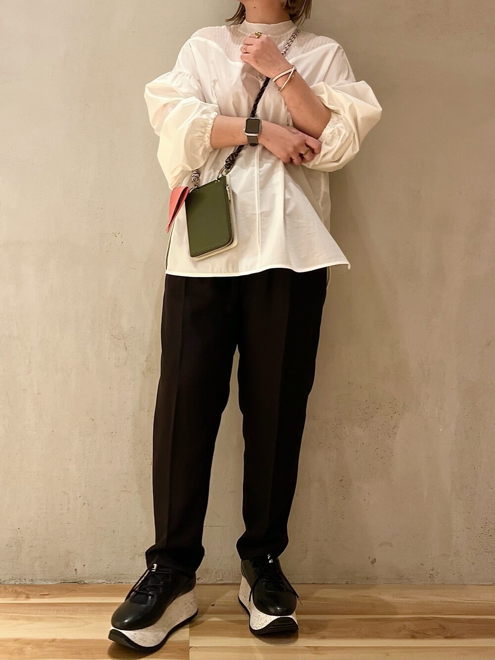 ベージュ系のショルダーバッグ、ブラック系のスニーカー、ブラック系のその他パンツを着用したレディースの冬コーディネートの3枚目の写真