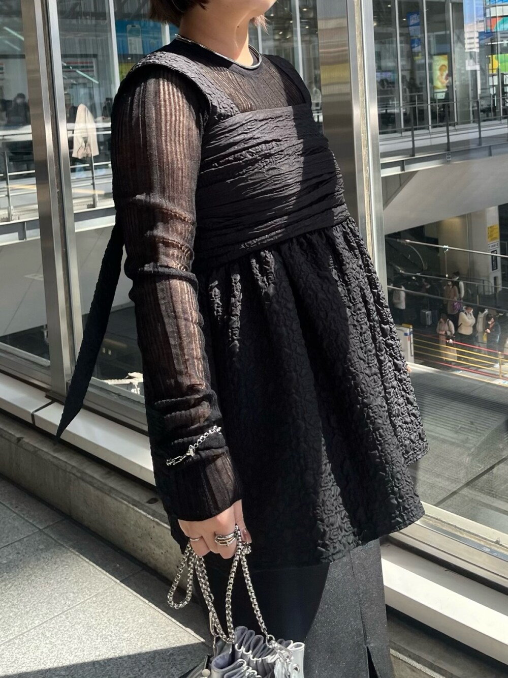 ブラック系のニット/セーター、ブラック系のシャツ/ブラウス、シルバー系のショルダーバッグを着用したレディースの春コーディネートの5枚目の写真