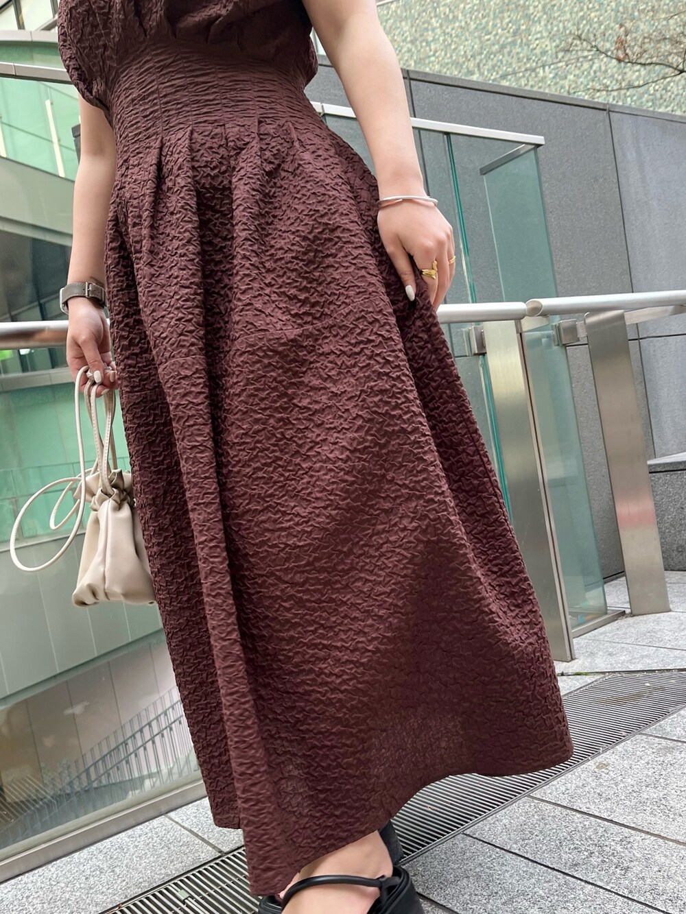 ブラック系のサンダル、ブラウン系のワンピース、シルバー系のネックレスを着用したレディースの冬コーディネートの6枚目の写真